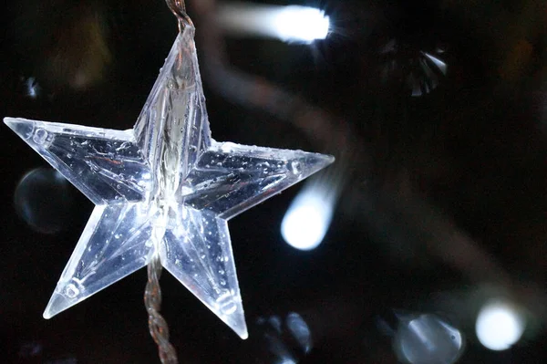 Luci bianche sull'albero di Natale. Decorazione a stella. Vigilia di Natale lucente in notte scura. — Foto Stock