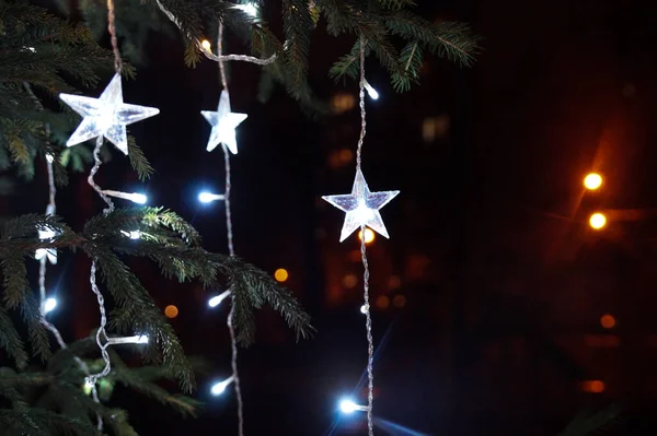 White lights on the Christmas tree. Star shaped decoration. Bright Christmas Eve in dark night. — Stock Photo, Image