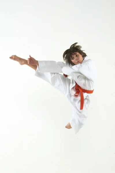 Pojke tränar karate på vit bakgrund — Stockfoto