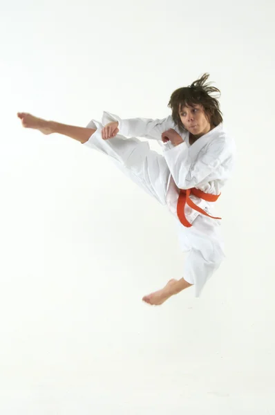 Pojke tränar karate på vit bakgrund — Stockfoto