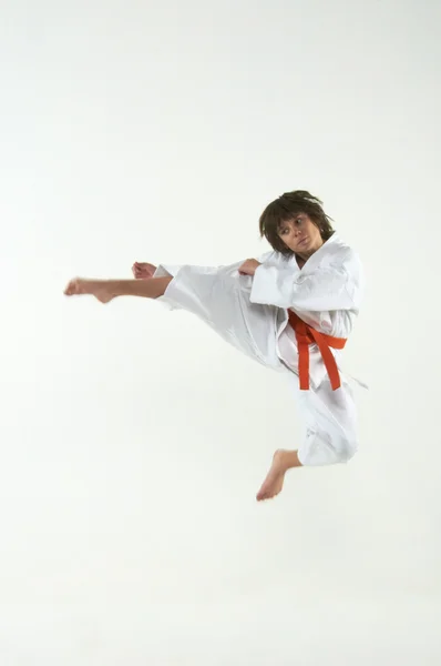 Pojke tränar karate på vit bakgrund — Stockfoto