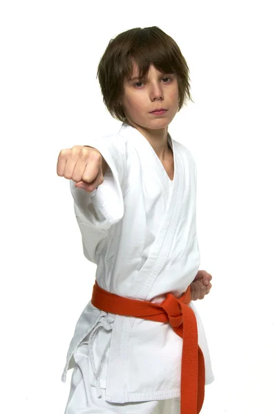 Pojke tränar karate på vit bakgrund — Stockfoto