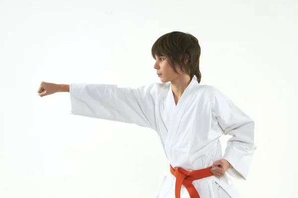 Junge praktiziert Karate auf weißem Hintergrund — Stockfoto