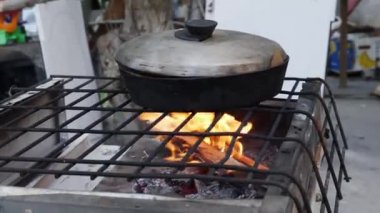 Mariupol şehrinde yıkılmış bir evin bahçesinde yemek pişirmek.