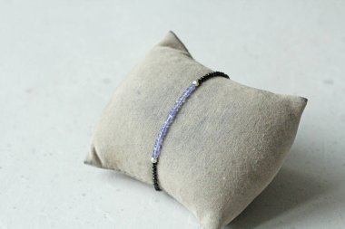 Tanzanya siyah bileziği. Doğal taştan yapılmış bilezik, Tanzanite, spinel. Doğal taşlardan yapılmış bilezik. El yapımı mücevherler. Hafif modern arkaplanda el yapımı bilezikler.
