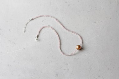 Gül kuvars, Kasumi inci kolye. Doğal gül kuvarsı, Kasumi inci taşlarından yapılmış bir kıza ait kısa bir kolye. Doğal taşlardan yapılmış el yapımı mücevherler. Modern mücevherler. Boynuna dola..