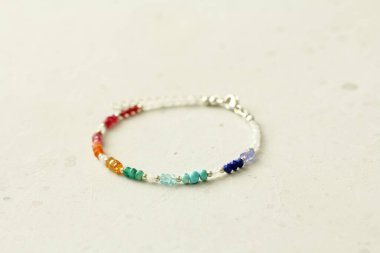 Parlak renkli bilezik. Doğal taştan yapılmış bilezik. Parlak, çok renkli. Doğal taşlardan yapılmış bilezik. El yapımı mücevherler. Hafif modern arkaplanda el yapımı bilezikler.