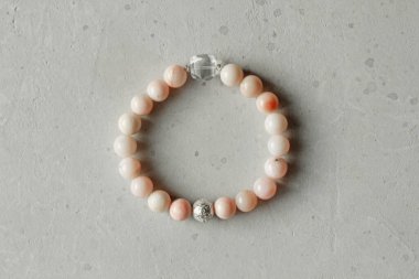 Pembe opal bilezik. Doğal taştan yapılmış bir bilezik. Pembe opal. Doğal taşlardan yapılmış bilezik. El yapımı mücevherler. Hafif modern arkaplanda el yapımı bilezikler.