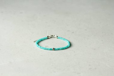 Amazon bileziği. Doğal taştan yapılma Amazonite bileziği. Doğal taşlardan yapılmış bilezik. El yapımı mücevherler. Hafif modern arkaplanda el yapımı bilezikler.