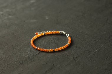 Doğal Carnelian ince bileziği. Doğal Carnelian taşlarından yapılmış bilezik. Doğal taşlardan yapılmış bilezik. El yapımı mücevherler. Siyah modern arkaplanda el yapımı bilezikler.