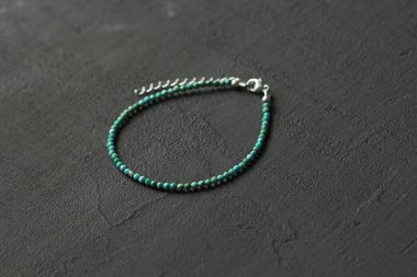 Turkuaz bilezik. Doğal Turkuaz taşından yapılma bilezik. Doğal taşlardan yapılmış bilezik. El yapımı mücevherler. Siyah modern arkaplanda el yapımı bilezikler.