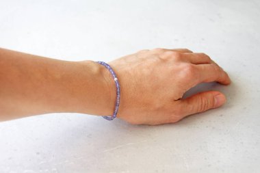 Tanzanit bilezik. Tanzanite 'in doğal taşından yapılmış taşlardan yapılmış bir bilezik. Doğal taşlardan yapılmış bilezik. El yapımı mücevherler. Hafif modern arkaplanda el yapımı bilezikler.