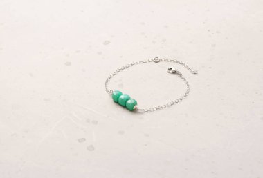 Krisopraz bileziği. Doğal taştan yapılmış Chrysoprase bilekliği. Doğal taşlardan yapılmış bilezik. El yapımı mücevherler. Hafif modern arkaplanda el yapımı bilezikler.