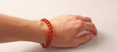 Cornelian bileziği. Doğal taş Cornelian taşlarından yapılmış bilezik. Doğal taşlardan yapılmış bilezik. El yapımı mücevherler. Hafif modern arkaplanda el yapımı bilezikler.