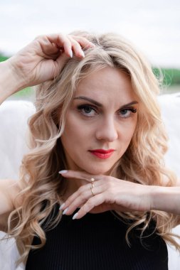 Beyaz melek kanatları olan hassas bir kadının portresi. Siyah deri kıyafetler giyiyordu. Karanlık melek düştü. İblis. hayvan