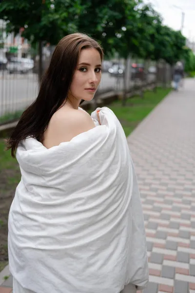 通りの白い毛布に身を包んだかなりブルネットの女性 クレイジー美しい千年紀の屈託のない女の子 — ストック写真