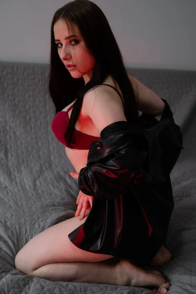 Νεαρή Γυναίκα Κόκκινα Εσώρουχα Και Δερμάτινο Μπουφάν Γκρι Κρεβάτι Σέξι — Φωτογραφία Αρχείου