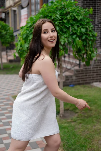 通りを走る白いタオルを着た自信に満ちたブルネットの女性 クレイジー美しい千年紀の屈託のない女の子 — ストック写真