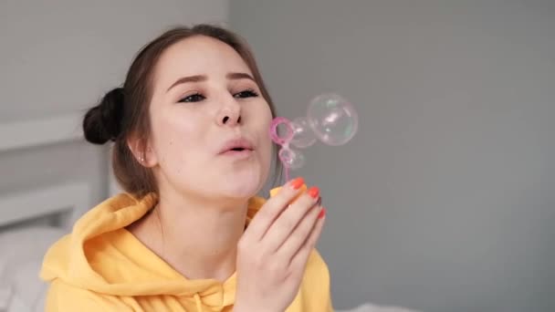Sarı Elbiseli Genç Kız Gri Arka Planda Sabun Köpüğü Yapıyor — Stok video