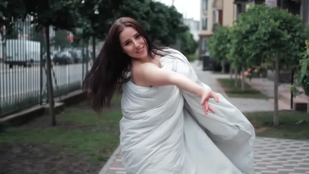 Mooi Meisje Een Witte Deken Lopen Door Straat Slow Motion — Stockvideo