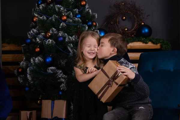 Niños felices jugando con regalos de Navidad. hermano y hermana cerca del árbol de Navidad dando regalos de año nuevo a los demás. tiempo familiar. hermanos amor. — Foto de Stock