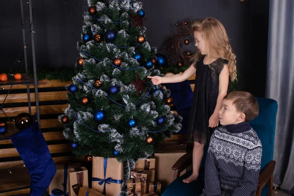 Niños muy encantadores - niño y niña - cerca del árbol de Navidad. Año Nuevo. amistad, niños. hermano y hermana - tiempo de familia en Navidad —  Fotos de Stock