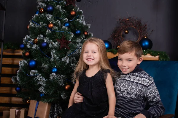 Ładne dzieci - mały chłopiec i dziewczynka - w pobliżu choinki. Nowy Rok. przyjaźń, dzieci. brat i siostra - czas rodzinny na Boże Narodzenie — Zdjęcie stockowe