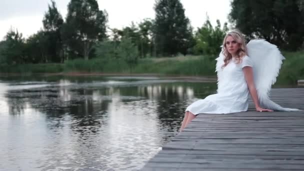 Beautiful angel in white dress. Amazing blond woman with long curly hair and white wings. slow motion — Stock Video