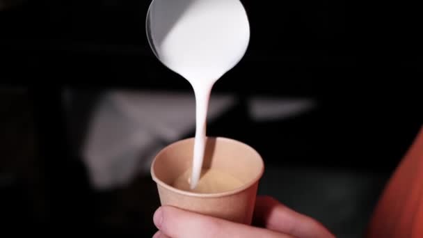 Barista giet latte foam op koffie, espresso. het creëren van een perfecte latte kunst. donkere kleuren, koffiehuis. slow motion — Stockvideo