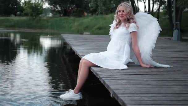 Portret van blonde vrouw in witte jurk en witte engelen vleugels. Goede mensen. Mijn hemel. Een paradijsengel. slow motion — Stockvideo