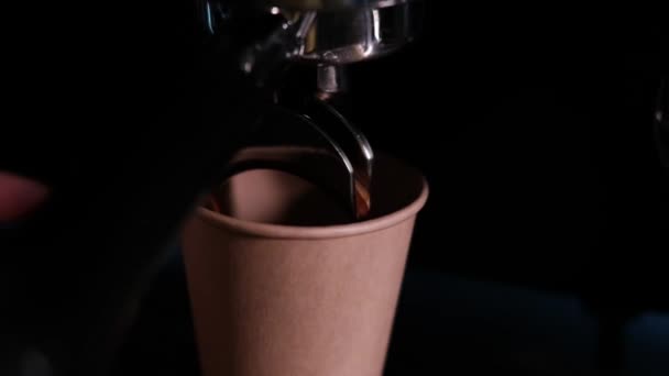 Fekete kávé ömlik a professzionális kávéfőzőből. Kávét főz a barista. Sötét loft kávézó. lassított felvétel — Stock videók
