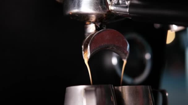 Černá káva se nalévá z profesionálního kávovaru. vaření kávy od baristy. tmavá kavárna. zpomalený pohyb — Stock video
