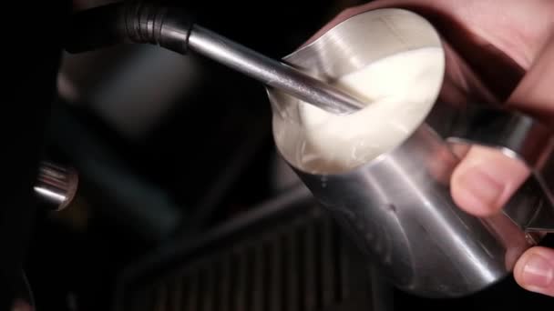 Процесс приготовления молочной пены для капучино или латте, нагрева и взбивания. Бариста варит молоко в кувшине. замедленное движение — стоковое видео