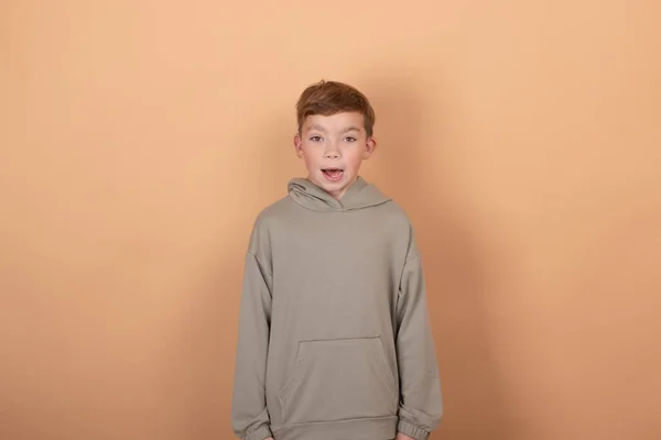 Tini fiú portré tinédzser elszigetelt barna háttérrel. Érzelmek az arcon. érzések és arckifejezés koncepció. hirdetés. másolás szabad hely szöveg — Stock Fotó
