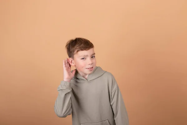 Tini fiú portré tinédzser elszigetelt barna háttérrel. Érzelmek az arcon. érzések és arckifejezés koncepció. hirdetés. másolás szabad hely szöveg — Stock Fotó