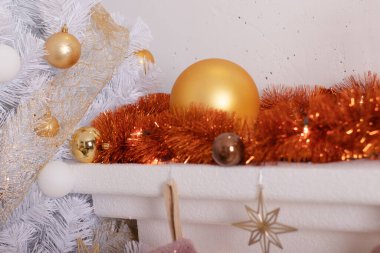 Odada yeni yıl atmosferi var. Beyaz Noel ağacıyla süslenmiş oturma odası. Şenlikli iç mekan, çelenkler, hediyeler. Odanın altın renkleri