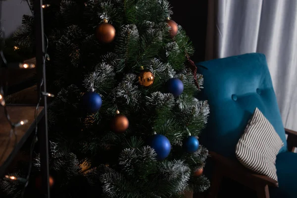 Stylový podkrovní interiér s krásným vánočním stromečkem. tmavě modré a hnědé a zlaté barvy. nové roky atmosféra dekorace. — Stock fotografie