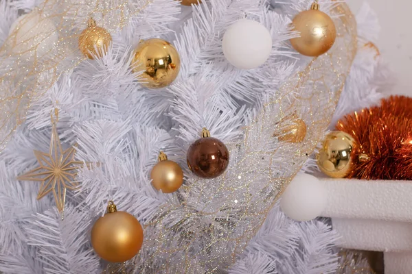 Την ατμόσφαιρα της Πρωτοχρονιάς στο δωμάτιο. Διακοσμημένο σαλόνι με λευκό χριστουγεννιάτικο δέντρο. εορταστικό εσωτερικό, γιρλάντες, δώρα. χρυσαφί αποχρώσεις του δωματίου — Φωτογραφία Αρχείου