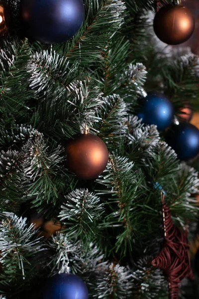 Zelené vánoční stromeček s modrými a hnědé a zlaté ozdoby koule bubliny na něm. oslava nového roku. kopírovat prostor pro text — Stock fotografie