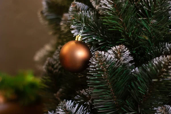 Primer plano de las ramas del árbol de Navidad y la decoración bolas y burbujas en oro, colores marrones en él. fondo. espacio de copia para texto — Foto de Stock