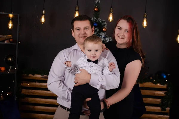 Happy european family. wife husband and a son. mother father and little boy. near christmas tree. happy new year and merry christmas. family time, happy holidays. young parents. formal clothing — Stockfoto
