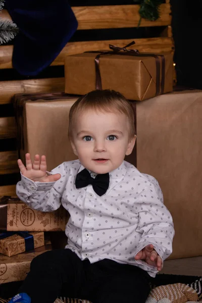 Little toddler blonde boy near christmas tree in dark loft room with blue decoration. happy new year — Stock fotografie