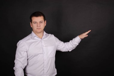 portrait of a handsome man in a white shirt on a black background. business style, office wear. businessman