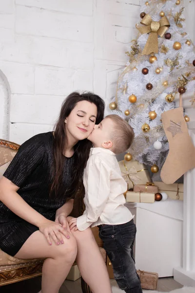 Portrait of happy woman and adorable baby boy celebrate Christmas. New Years holidays. Toddler with mom in the festively decorated room with Christmas tree and decorations. single mother — Stockfoto
