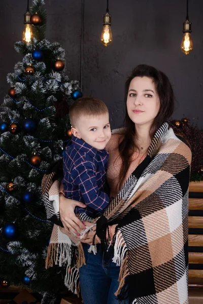 Anak kecil dengan wanita di dekat pohon natal dan dekorasi. anak dan ibu pada malam Natal. Tahun baru. Ibu tunggal. keluarga tidak lengkap — Stok Foto
