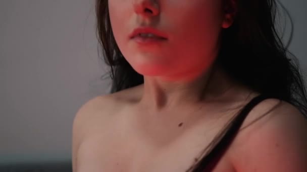 Sexy femme brune confiante en sous-vêtements rouges et veste en cuir sur lit gris — Video