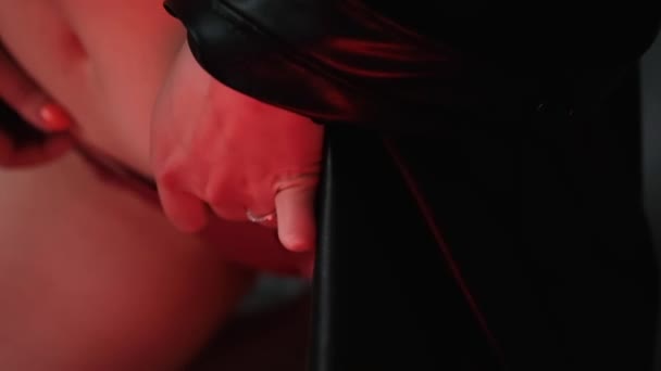 Brune sexy en sous-vêtements rouges et veste en cuir posant en lumière rouge dans la pièce sombre — Video