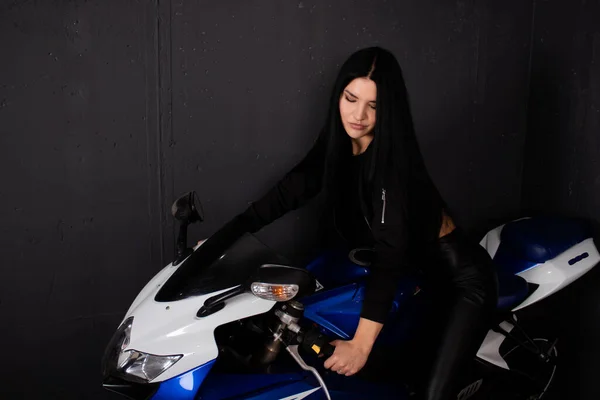 Mulher sexy em roupas de couro preto em uma motocicleta azul. Uma condutora. moto esporte — Fotografia de Stock