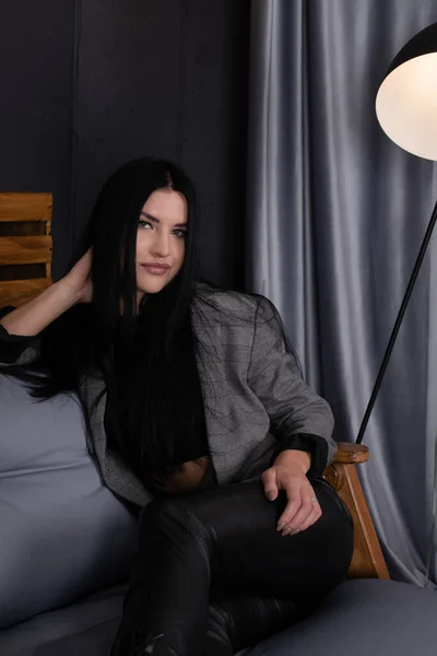 Mladá atraktivní žena v černém v šedé podkrovní místnosti. Módní oblečení. módní ženský portrét — Stock fotografie