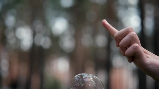 Flickor fingerpullar en såpbubbla. Inget ansikte. suddig bakgrund — Stockvideo